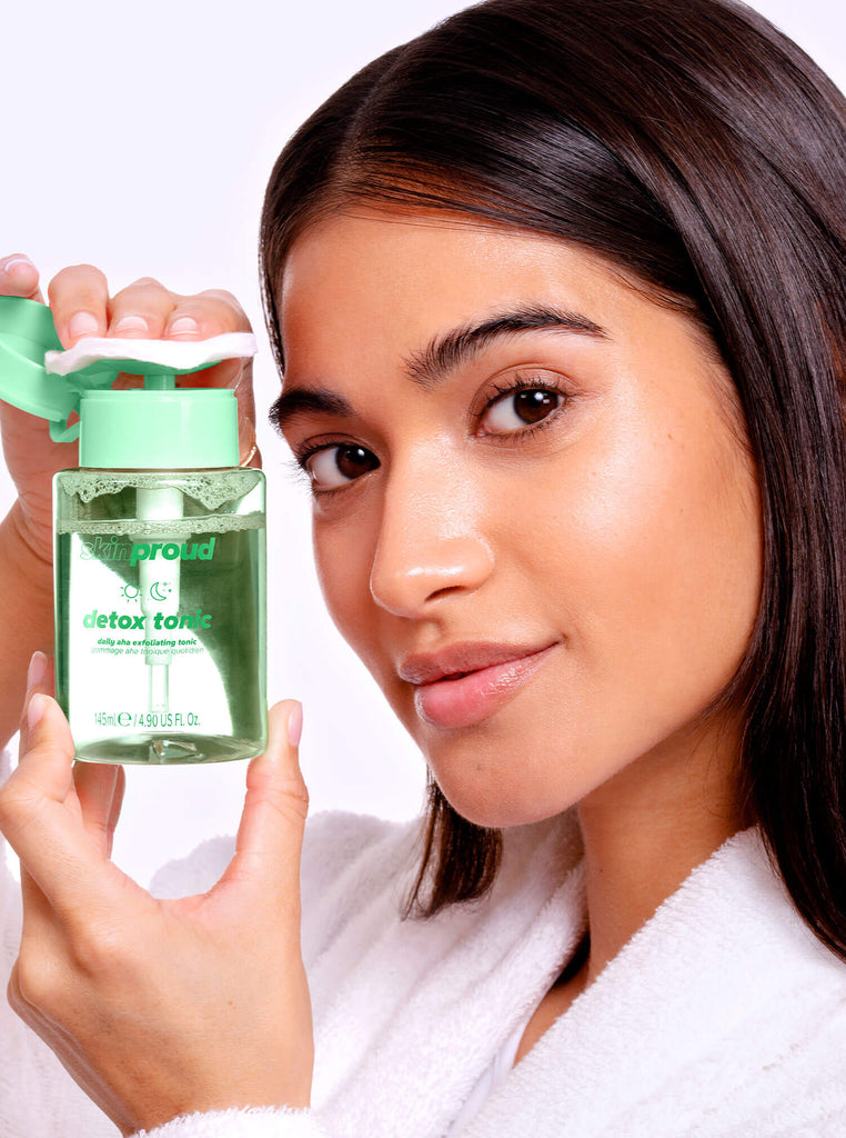 Model holding a bottle of Detox Tonic and a cotton pad
