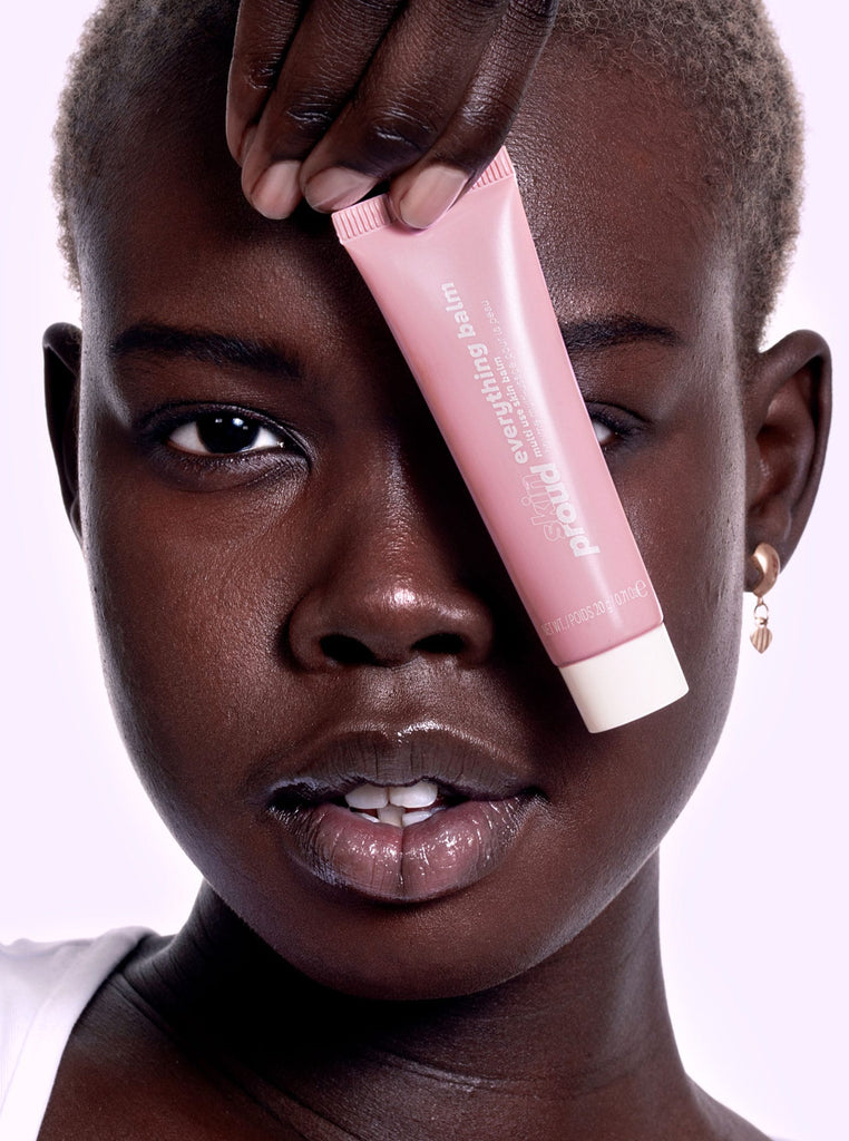Model holding tube of Everything Balm in front of her face