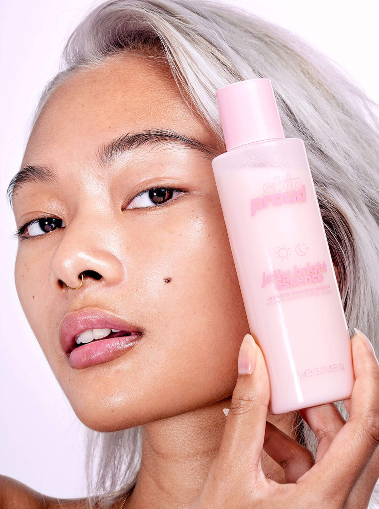 Model holding Jelly Bright Essence bottle next to face